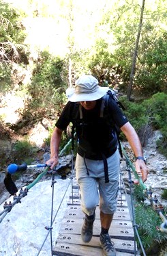 El Maestro, circunspecto, asegurando cada pie sobre el puente colgante