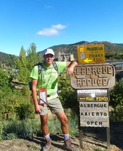 Romerillo ante los carteles de los albergues de Villafranca